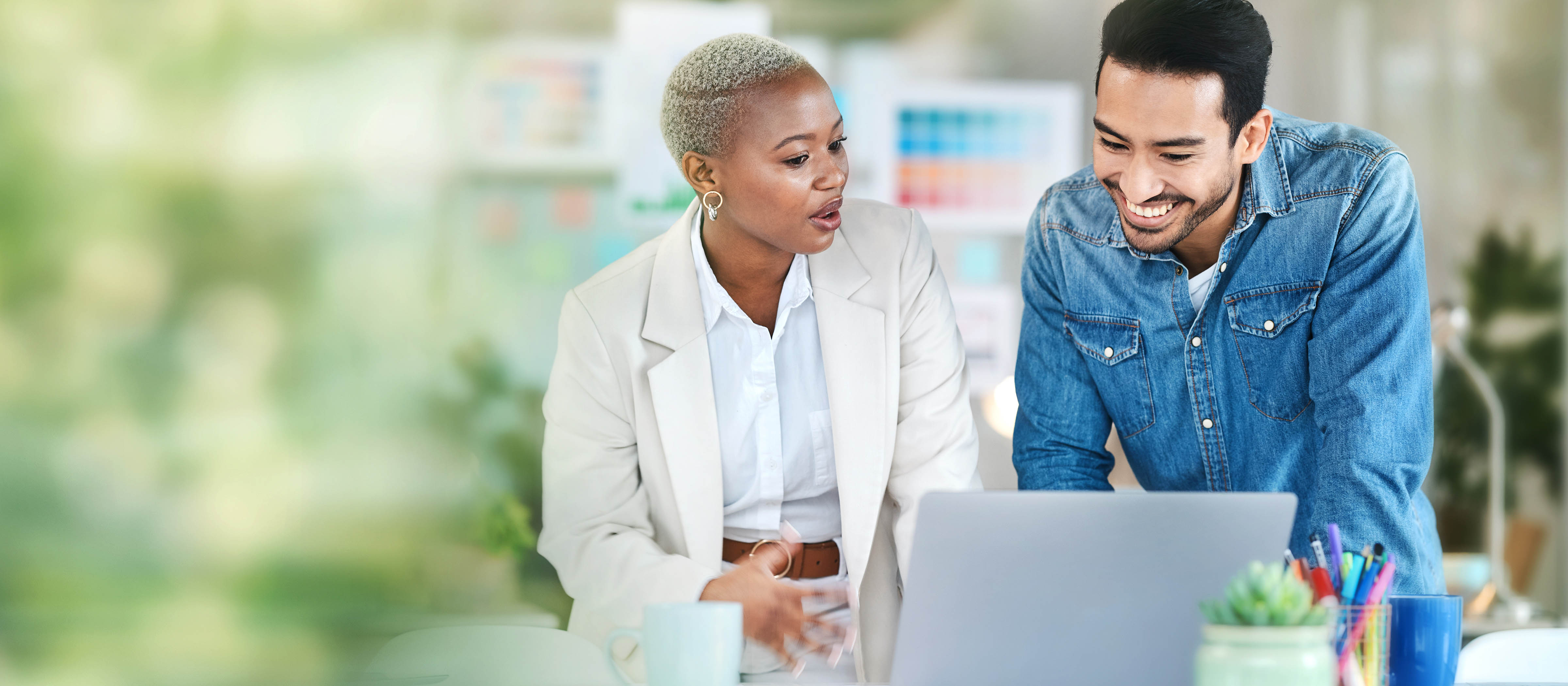 man and women looking at laptop and discussing project