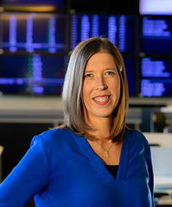 a portrait of a woman with screens behind her