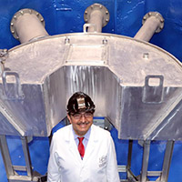 a man in a lab coat stands in front of a device in a nuclear reactor