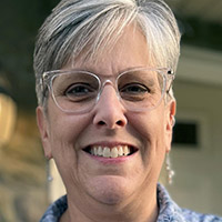 a headshot of a woman wearing glasses 