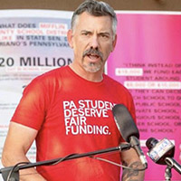 a man in front of a microphone at a podium