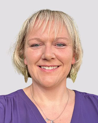 A headshot of a woman with short blonde hair.
