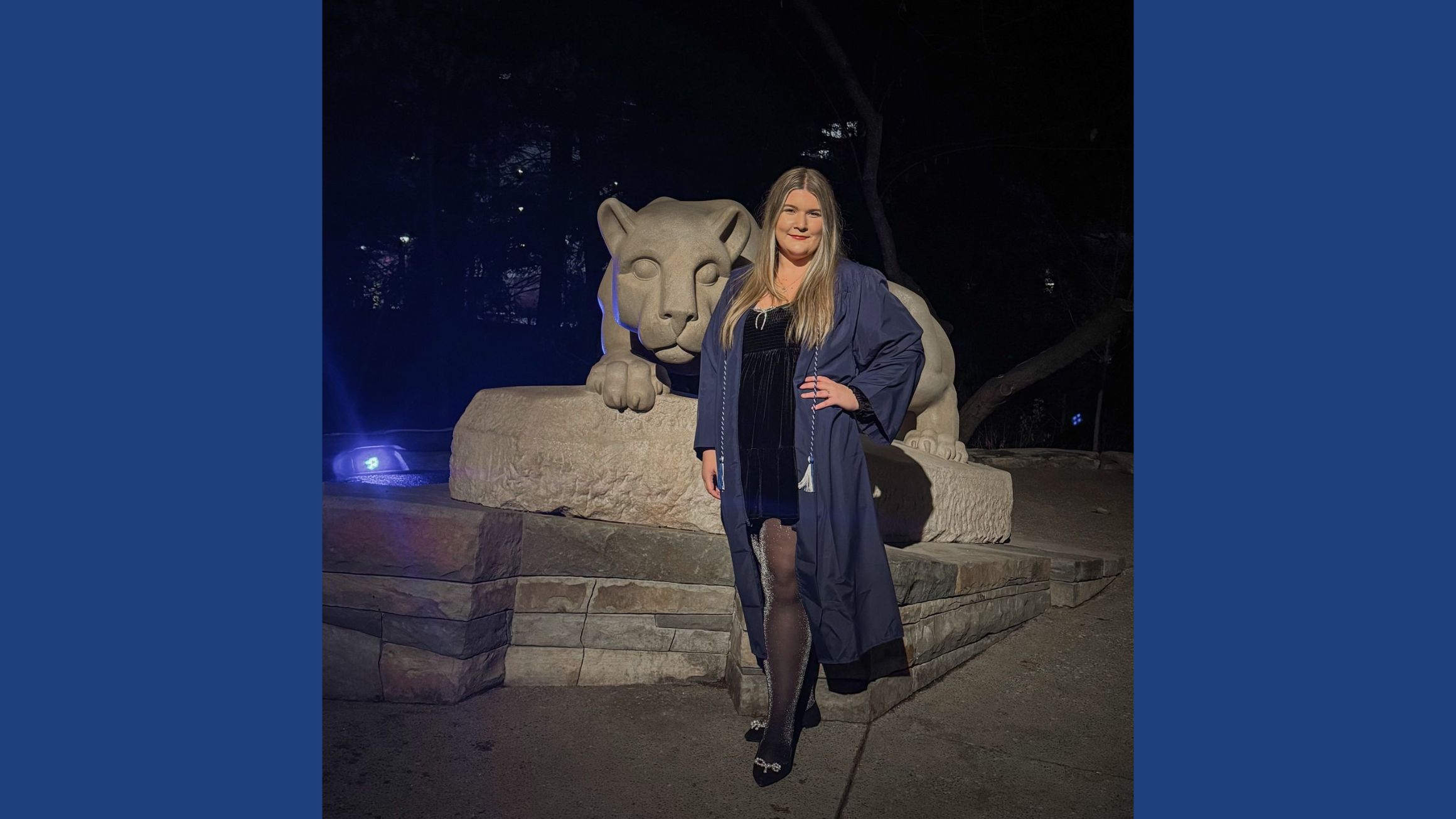 Jillian Lesikar, wearing a graduation gown, poses in front of the Nittany Lion shrine statue