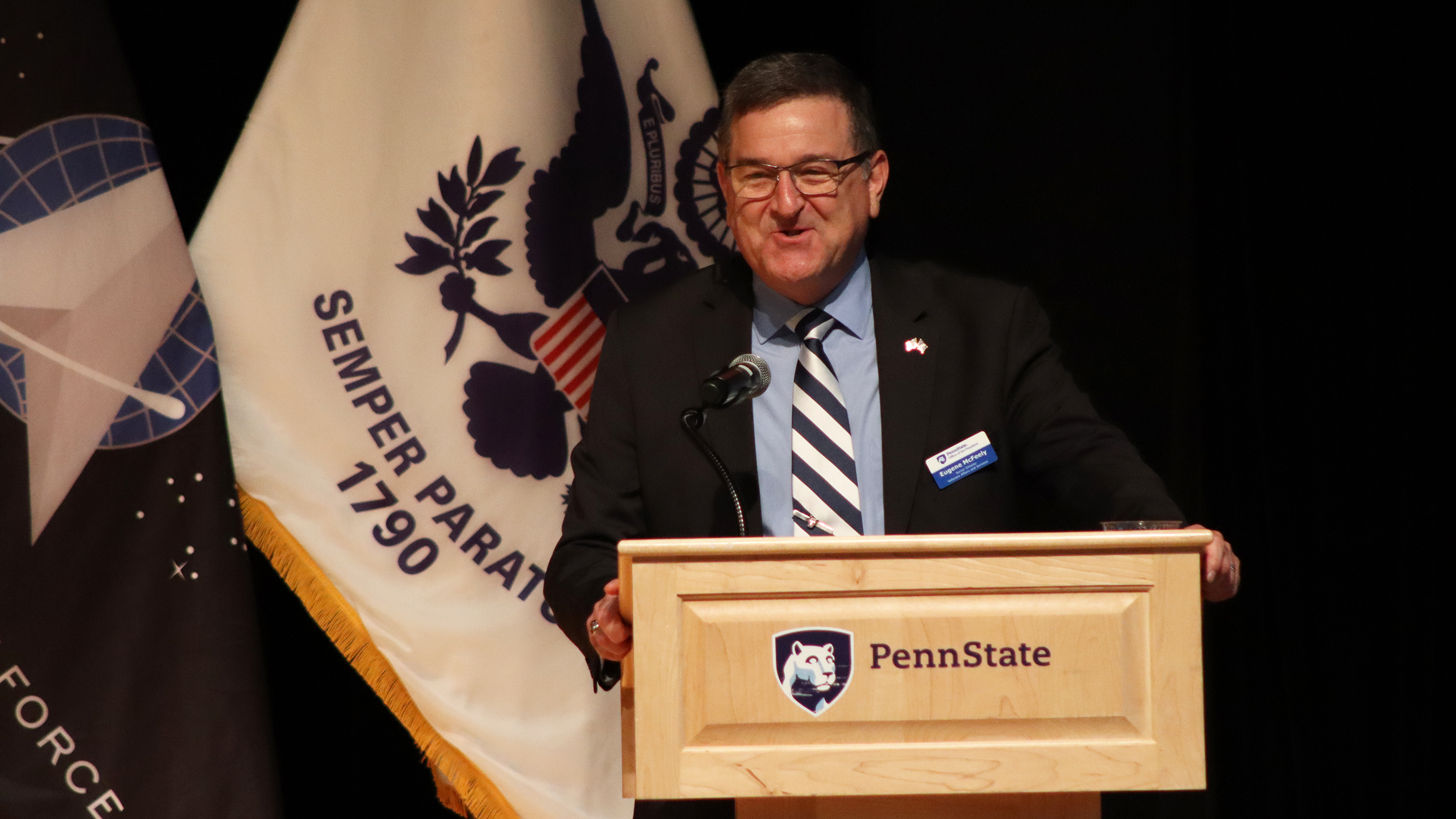 A man stands at a podium and speaks to an audience.