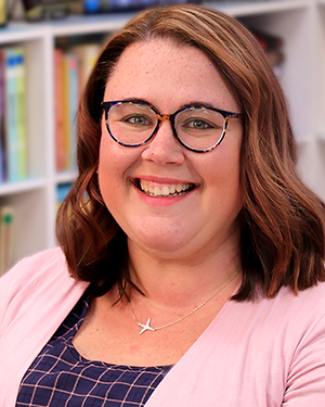 A headshot of a woman in front of a bookshelf.