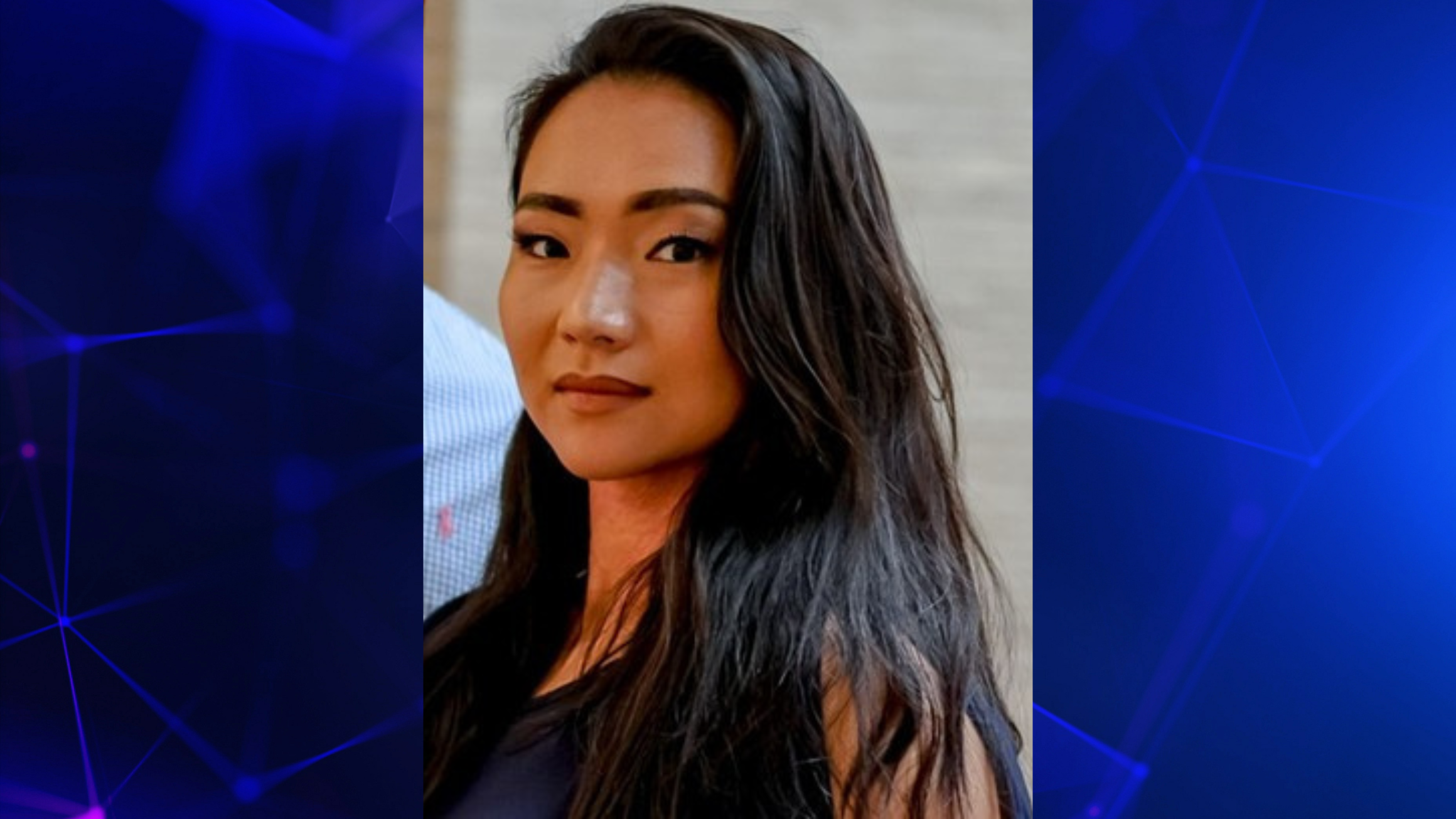 A professional headshot of a woman against a blue background.