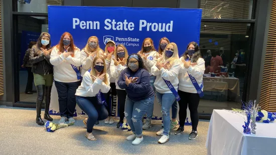 Members of the Penn State Homecoming Committee and the inaugural court huddle together for a group photo