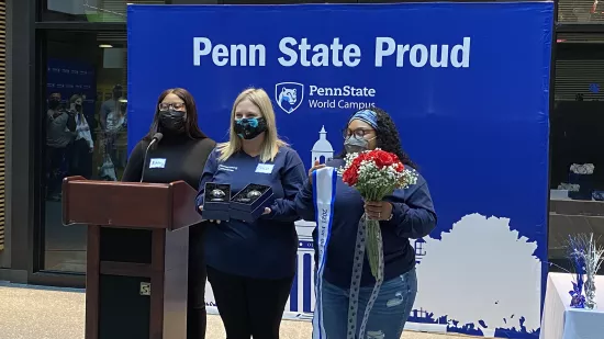 Ashley Adams and two members of the homecoming committee show the For the Glory Award