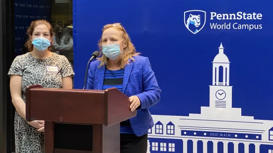 Two Penn State World Campus staff members, Amber Redmond and Julie Fitzgerald, address the audience of the homecoming court recognition ceremony on Friday, Oct 22.