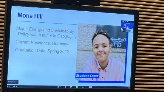 A presentation slide shows Mona Hill