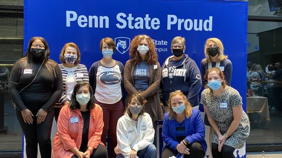 Ten Penn State World Campus staff members pose for a photo at the homecoming recognition ceremony.