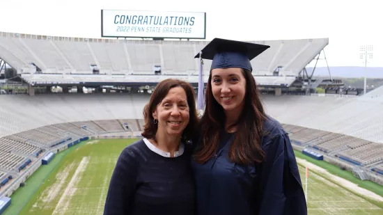 Joanna Allgood and her mother pose for a photo with the field and bleachers of Beaver Stadium in the background