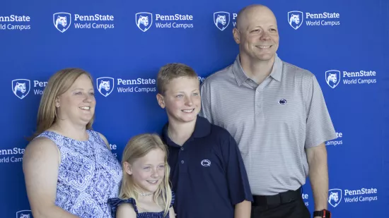 A man and woman pose for a photo with two children.