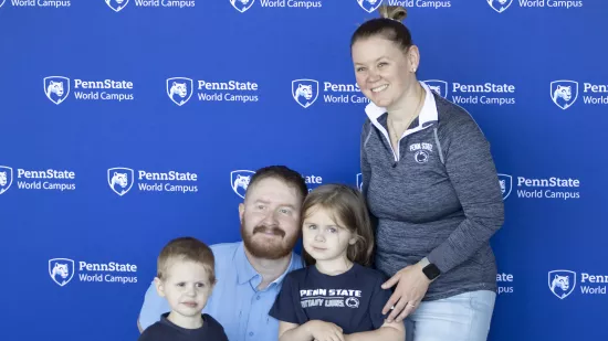 A man and woman pose for a photo with two children.