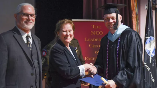 Jason Buschow shakes hands with Renata Engel while Will Diehl looks on