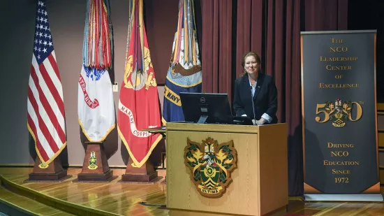 Renata Engel speaks at a podium on a stage
