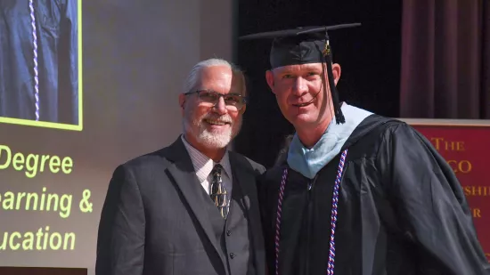 Sean O'Brien poses for a photo with Will Diehl on a stage