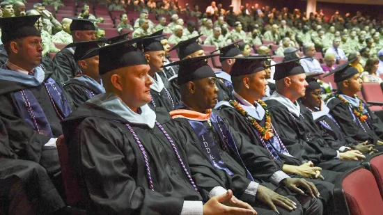 Fellows are showing sitting in seats in an auditorium