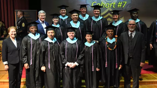 The Penn State fellows pose for a photo on a stage 