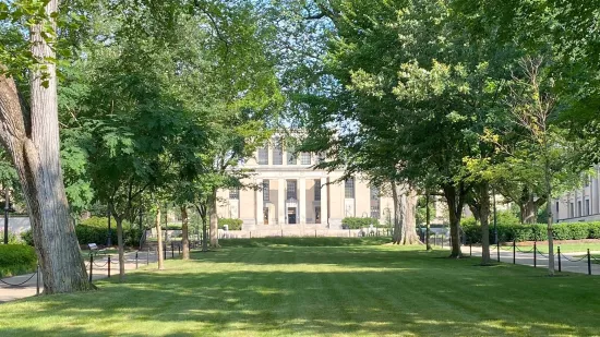 The entrance to Pattee Library is shown, with a large lawn in the foreground