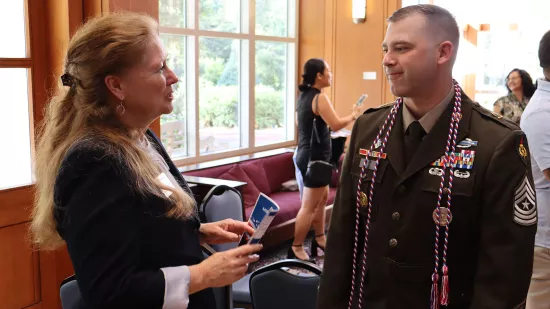 A woman and a man in military uniform talk