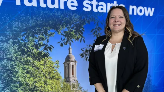 A woman stands in front of a Penn State-themed backdrop.