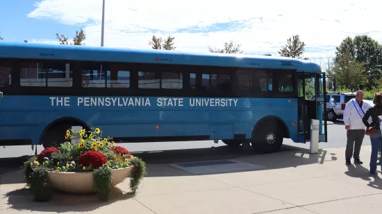 A blue bus is parked in a parking lot.