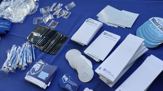 Penn State World Campus Alumni themed pens, stickers and notepads sit on a table.