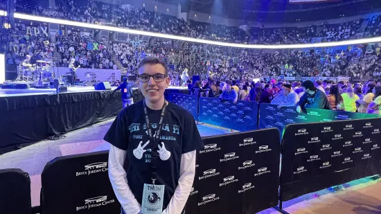 A man stands in a crowded arena.