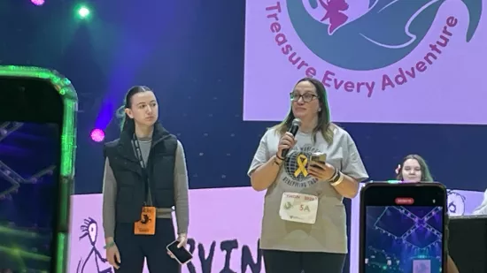 Two women stand on a stage.