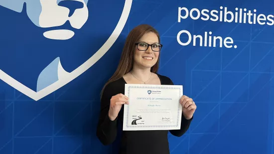 A woman holds a certificate against a backdrop of the logo of World Campus.