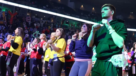People dance in a crowded arena.