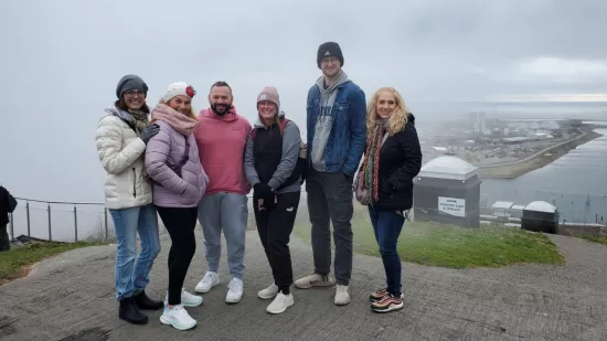 six people stand overlooking the city below