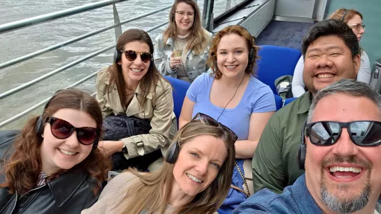 Seven people take a selfie photograph on a boat.