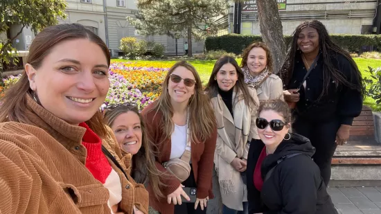 Seven women pose for a photo in a park.