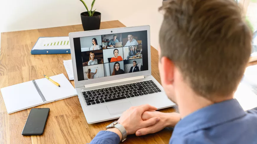 A man looking a computer during a Zoom meeting.