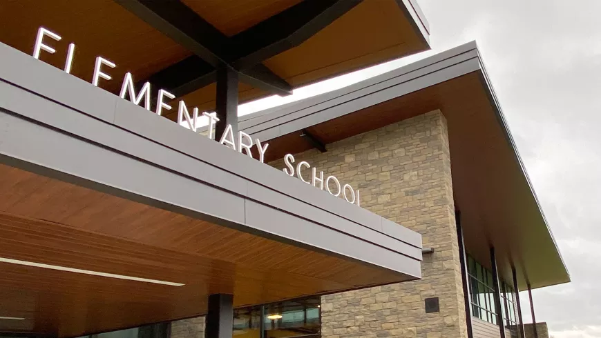the words "elementary school" are part of a sign on top of the awning of an entrance to a school