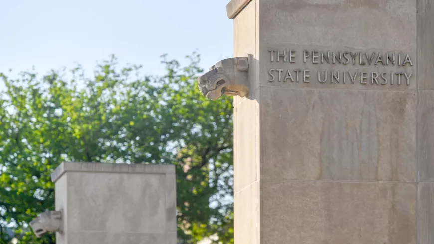 Two concrete pillars show a lion's head on each and the text "The Pennsylvania State University."