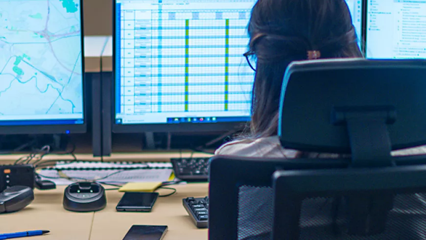 Decorative image of a woman monitoring multiple computer screens