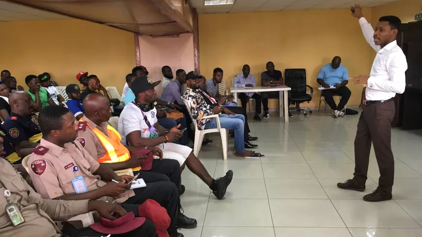 Abiodun Awoyemi gives a demonstration in front of a crowd sitting in chairs in a conference room.