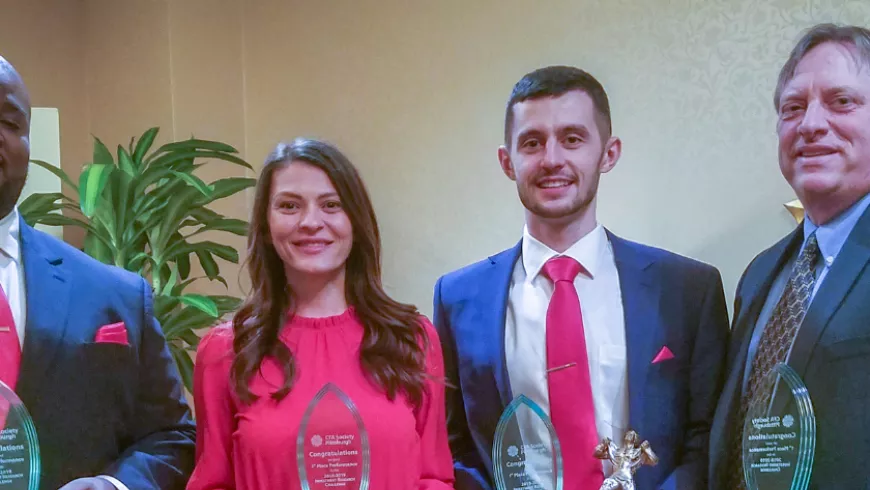team members pose with awards