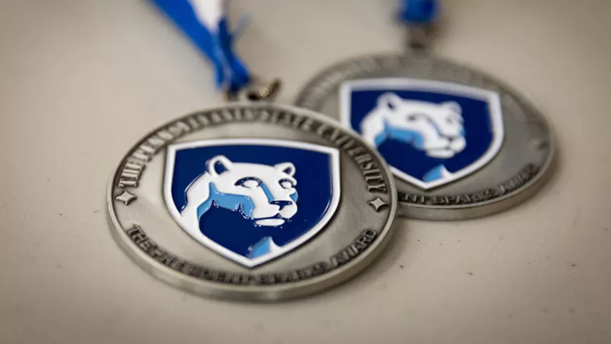Two medals with the Penn State logo on shown