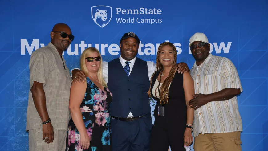 Five people pose in front of a blue Penn State background.