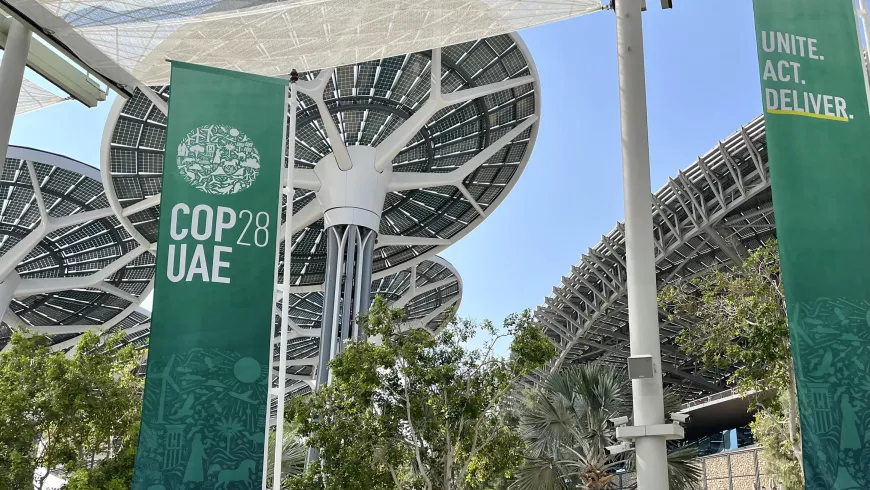 The name of COP28 is on a banner hanging from the entrance at the conference