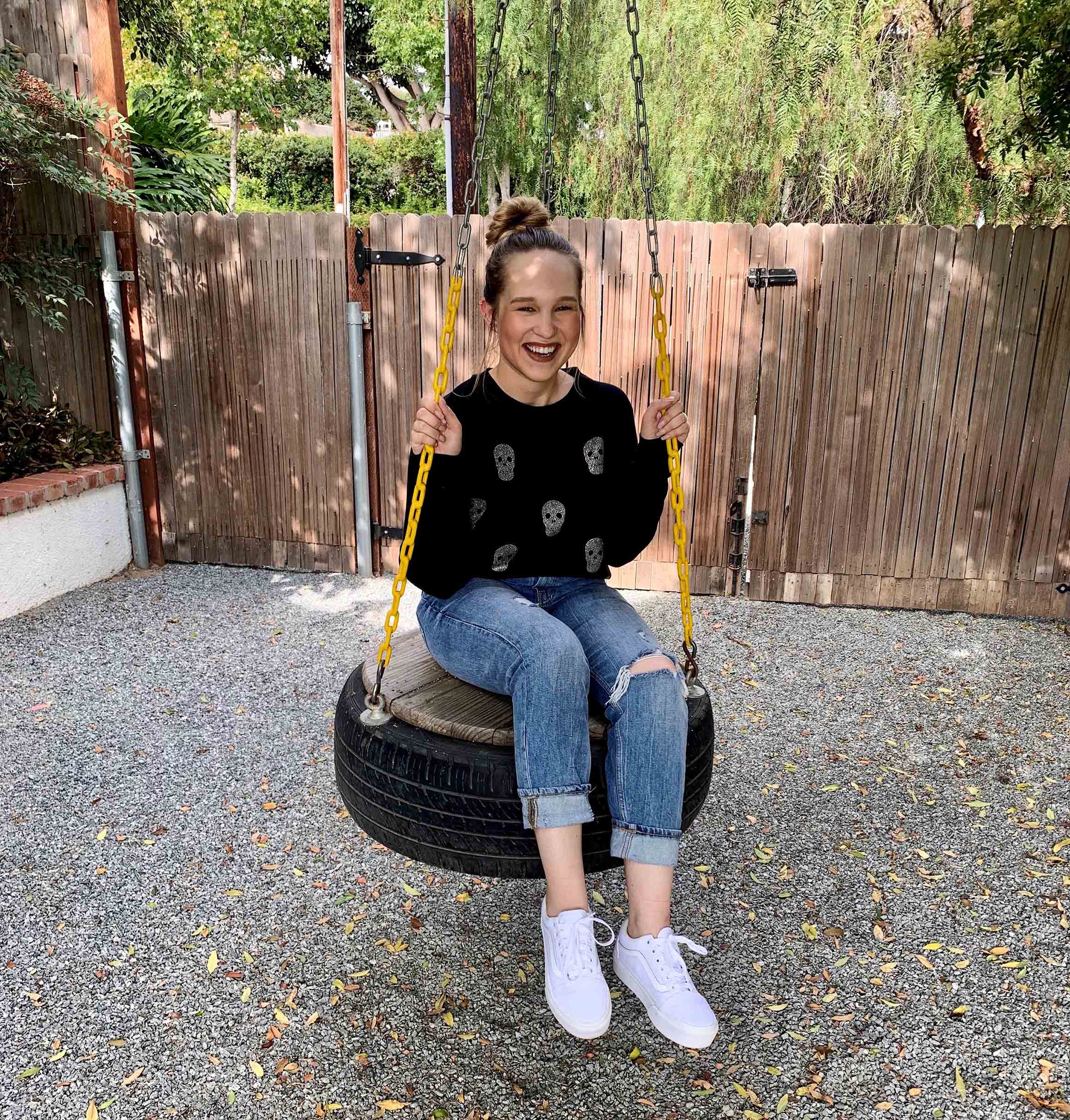 Sydney Rhead sits on a tire swing