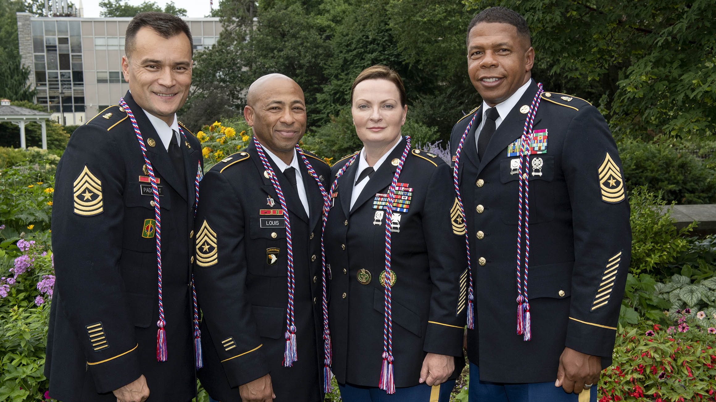Four sergeants major in the Army pose for a photo with Army uniforms and military honor cords