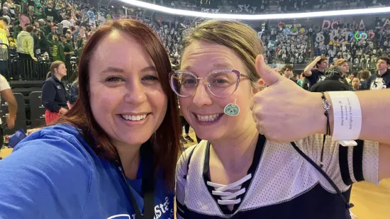 Two women take a selfie in an arena.